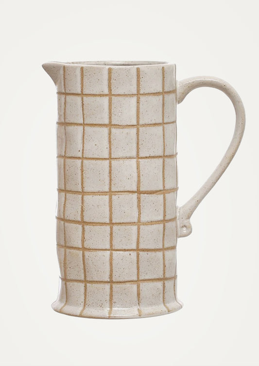 Ceramic pitcher with grid pattern on a white background.