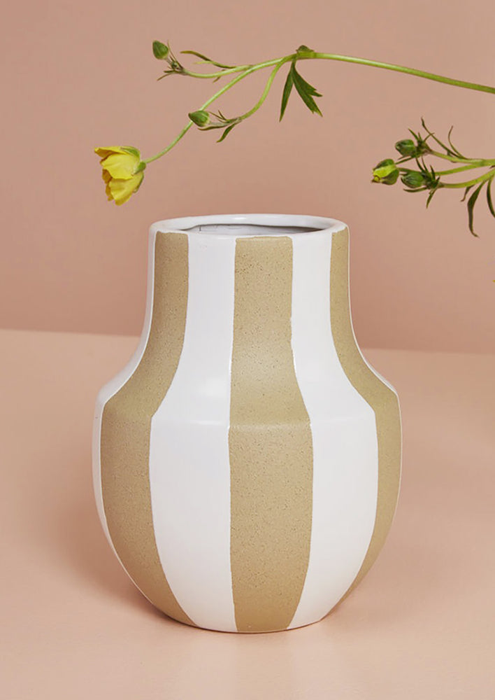 2: A sand ceramic vase with vertical white stripes and sculptural shape.