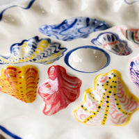 2: A handmade ceramic oyster plate with colorful painted oyster design.
