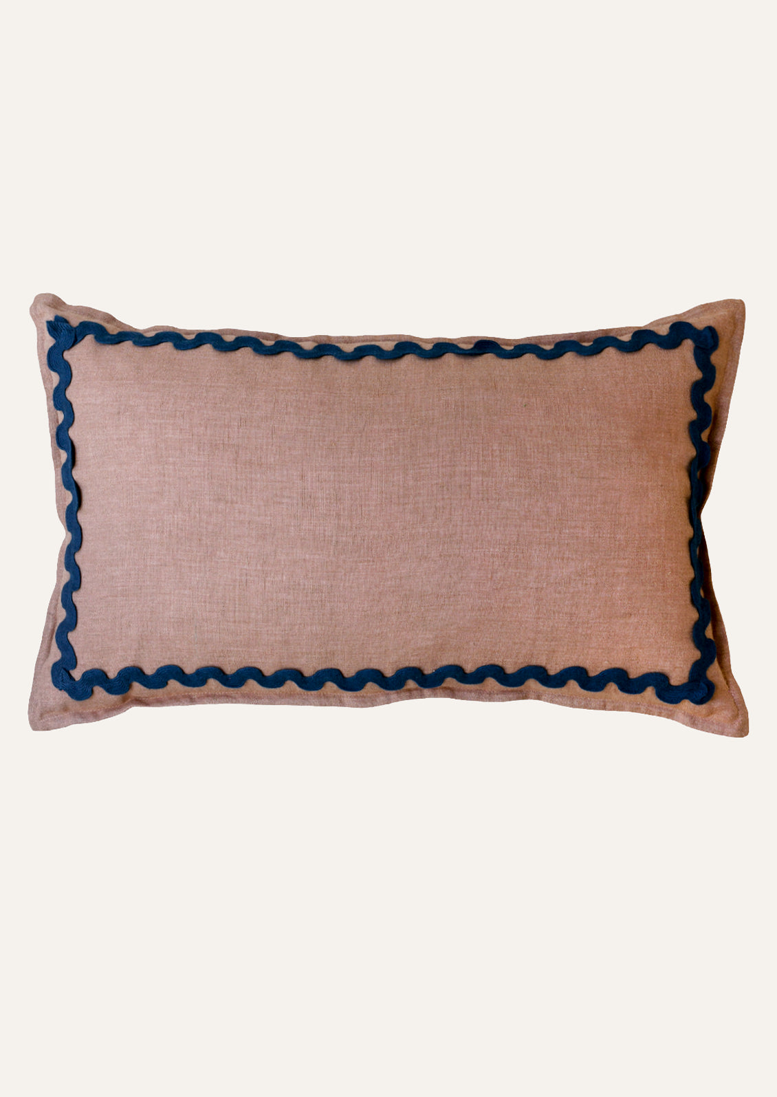 A rectangular linen pillow in a mauve color with a navy squiggle border attached along the edges.