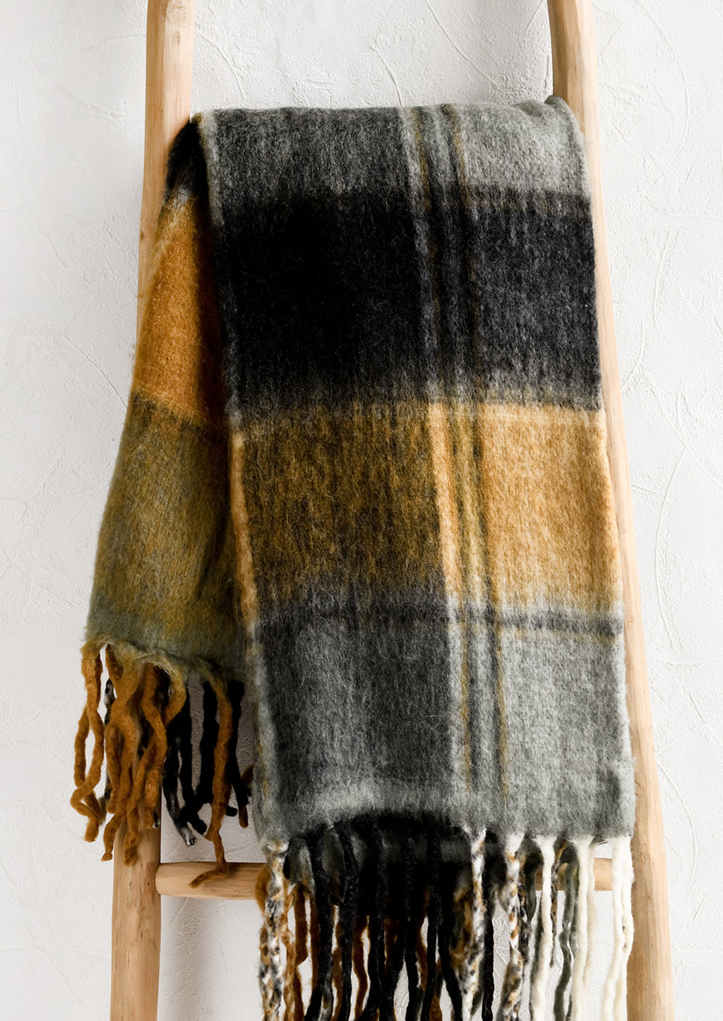 1: A mohair throw blanket with plaid pattern in grey, black and caramel.