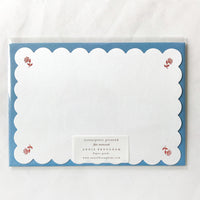 Ruby Floral: A scalloped white notecard with red floral at corners and blue envelope.