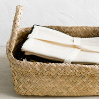 3: A rectangular seagrass basket with rolled top rim and side handles.