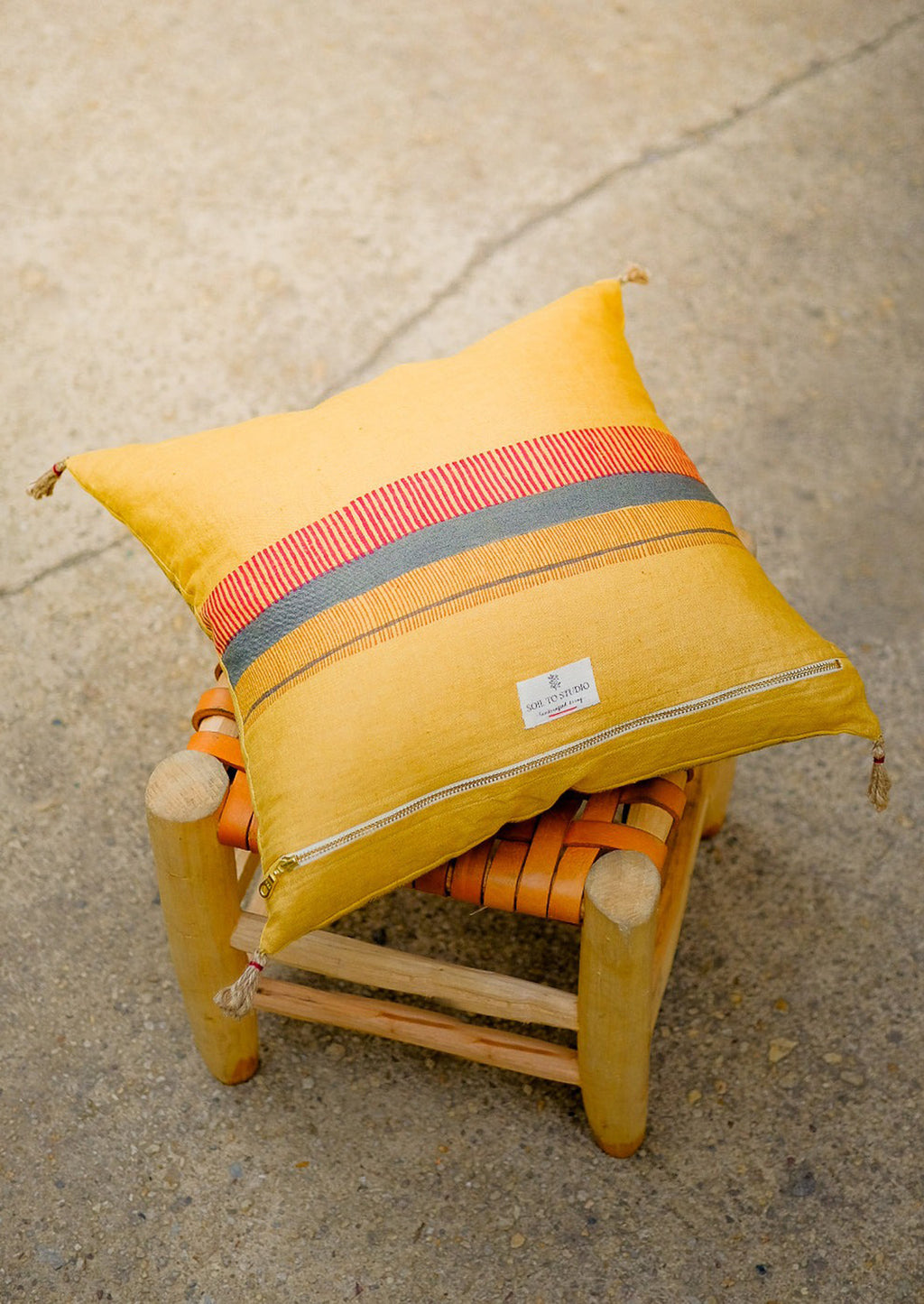 2: The back of the pillow with decorative stripe detailing and zip closure.