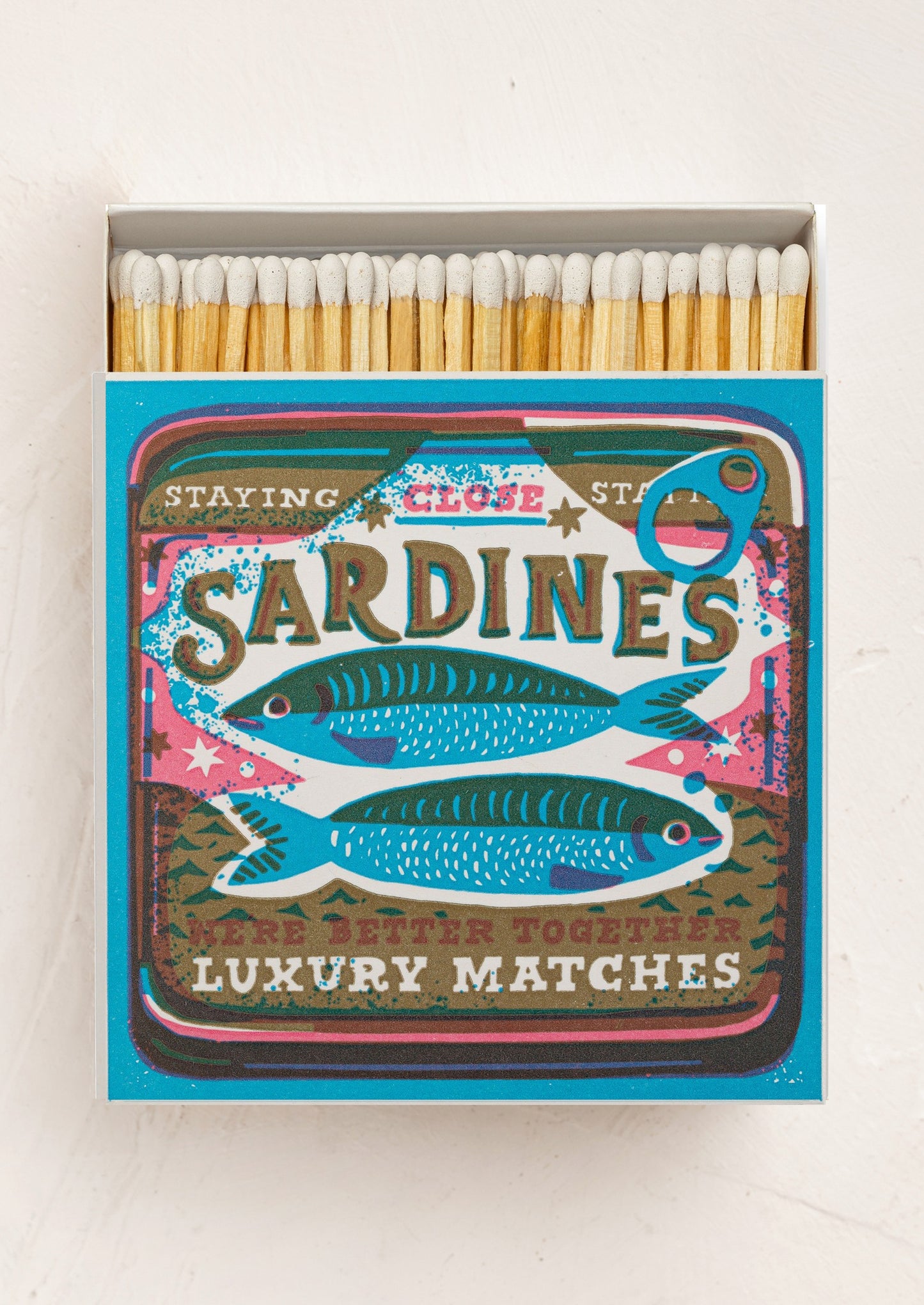 Matchbox with 'Sardines' design and white tipped matches inside.