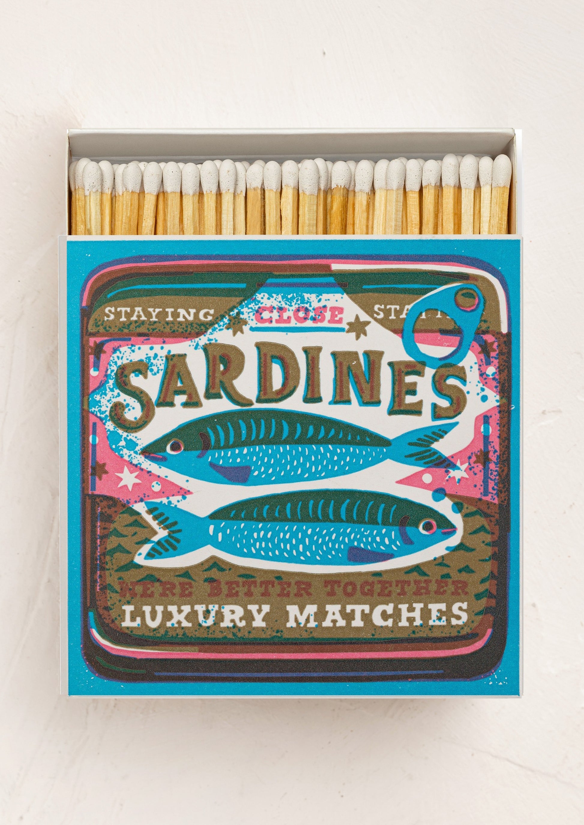 Matchbox with 'Sardines' design and white tipped matches inside.