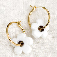 White: A pair of gold hoop earrings with single white flower bead.