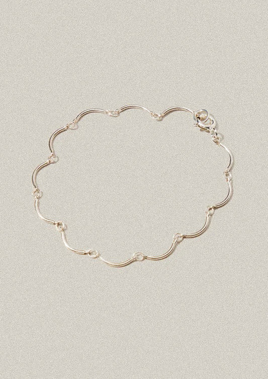 Silver bracelet on a light gray background
