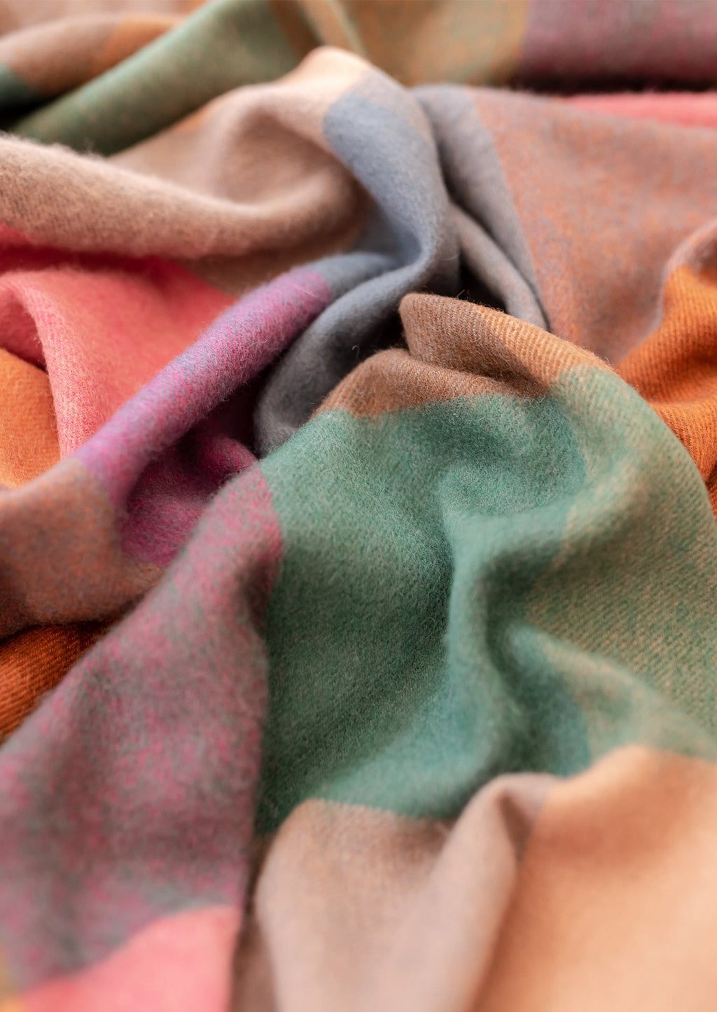 3: A madras check print wool throw in shades of peach, pink, teal, orange and blue.