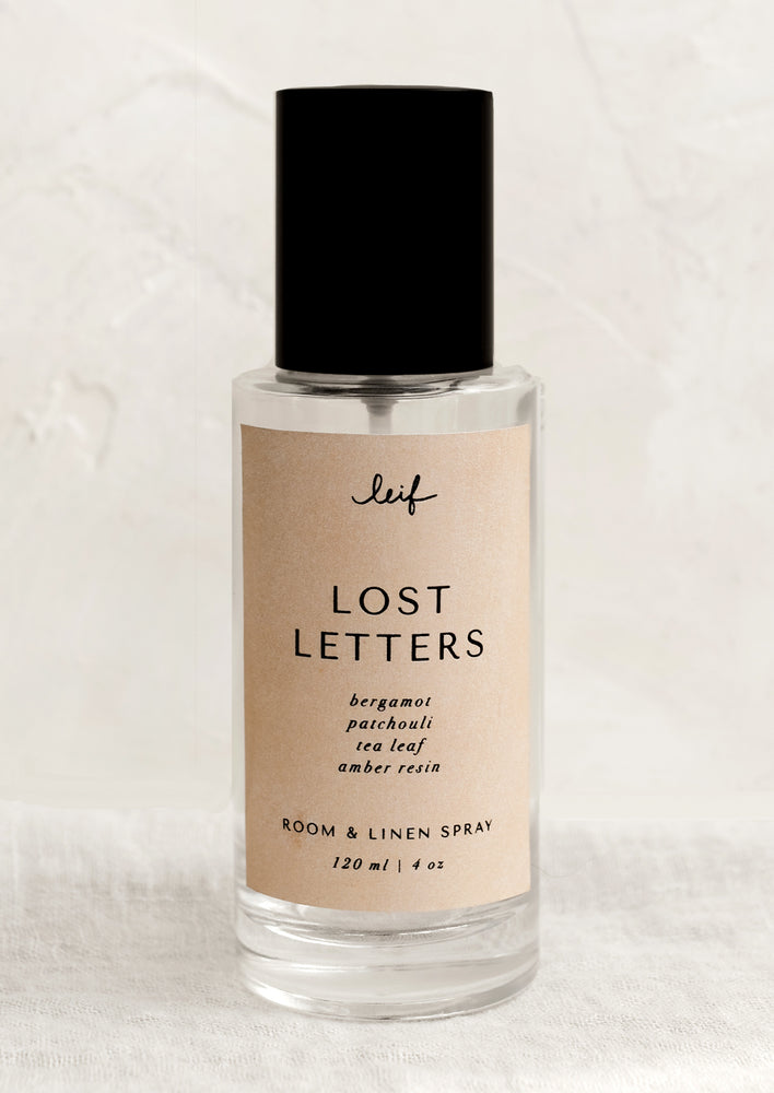Lost Letters: A room spray bottle with printed text on beige label.