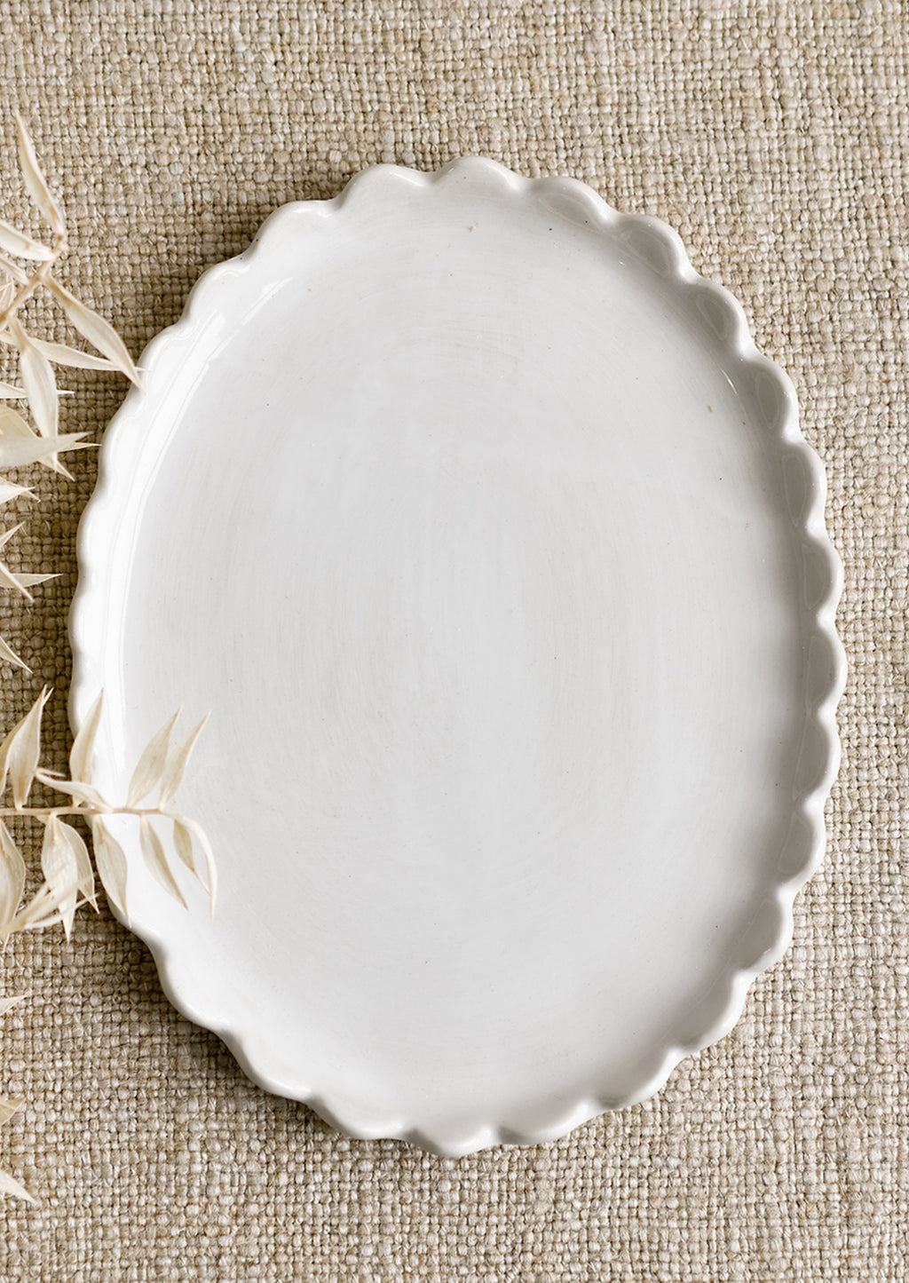 White: A white ceramic oval tray with scalloped edges.