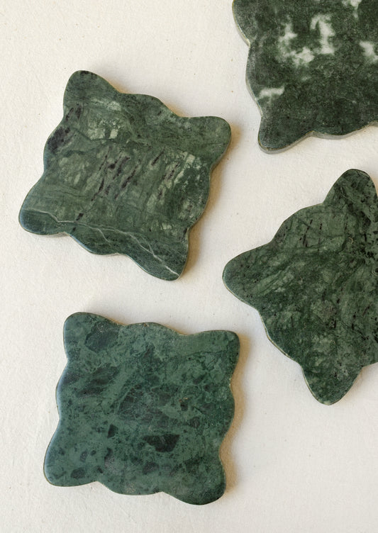 A set of 4 green marble coasters with scalloped edges.