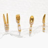 Gold: A set of four gold stud earrings in shape of chopsticks, fork, spoon, and knife.
