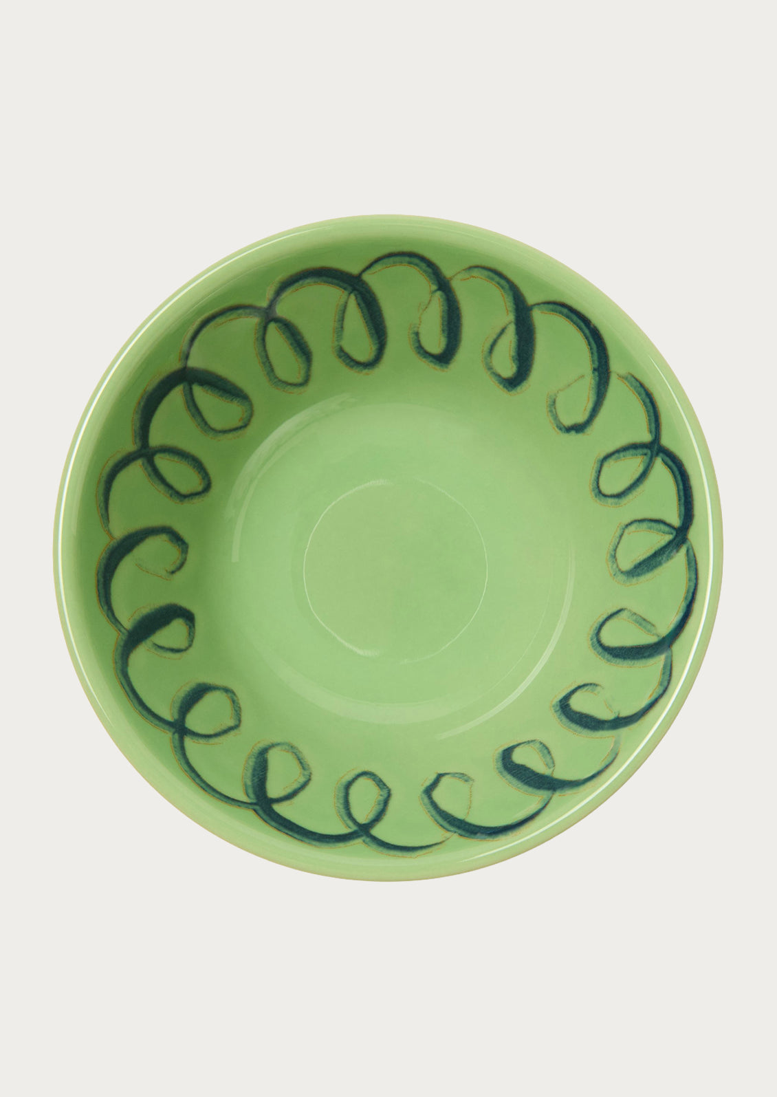 A green bowl with a squiggle design along the edge.