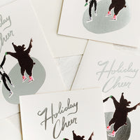 1: A set of cards depicting an ice skater and bear skating on silver pond, text reads "Holiday cheer".