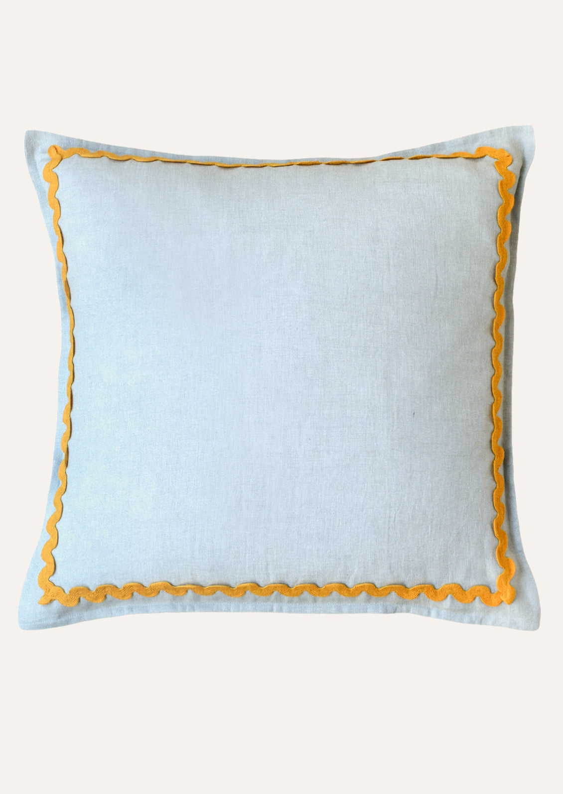A square linen pillow in a sky blue color with a yellow squiggle border attached along the edges.