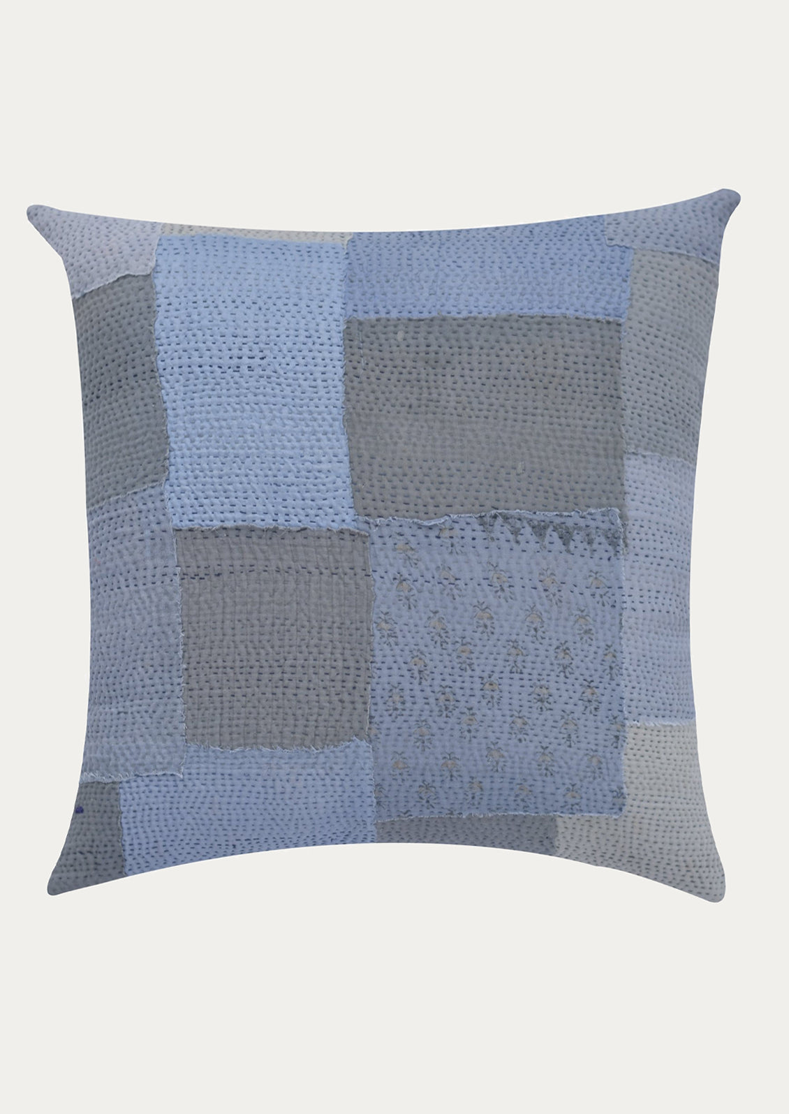 Blue and gray patchwork pillow on a white background
