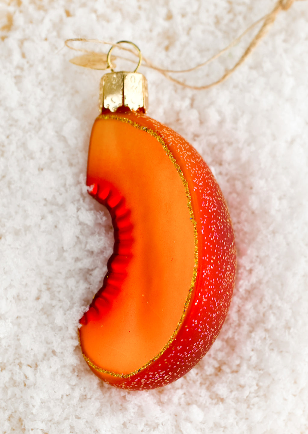 2: A glass ornament in the shape of a sliced peach.