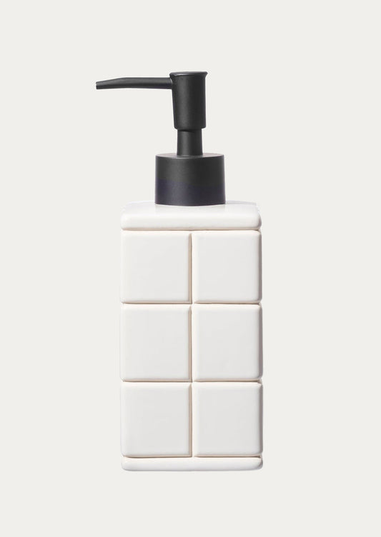 A tiled white ceramic soap dispenser.
