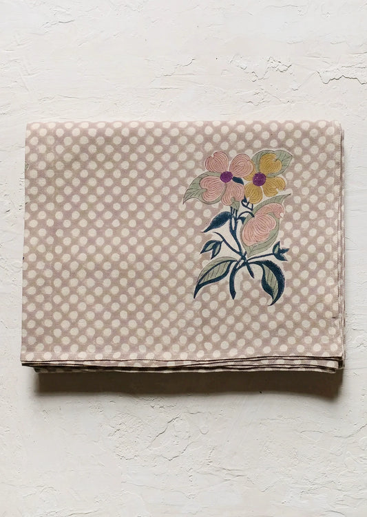 A polka dot tablecloth with floral motif.