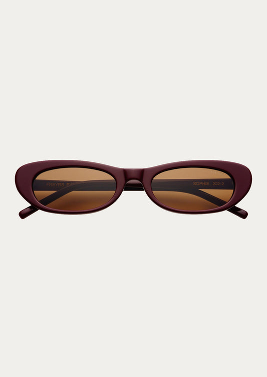 A pair of cat eye sunglasses with burgundy frames and brown tinted lenses.