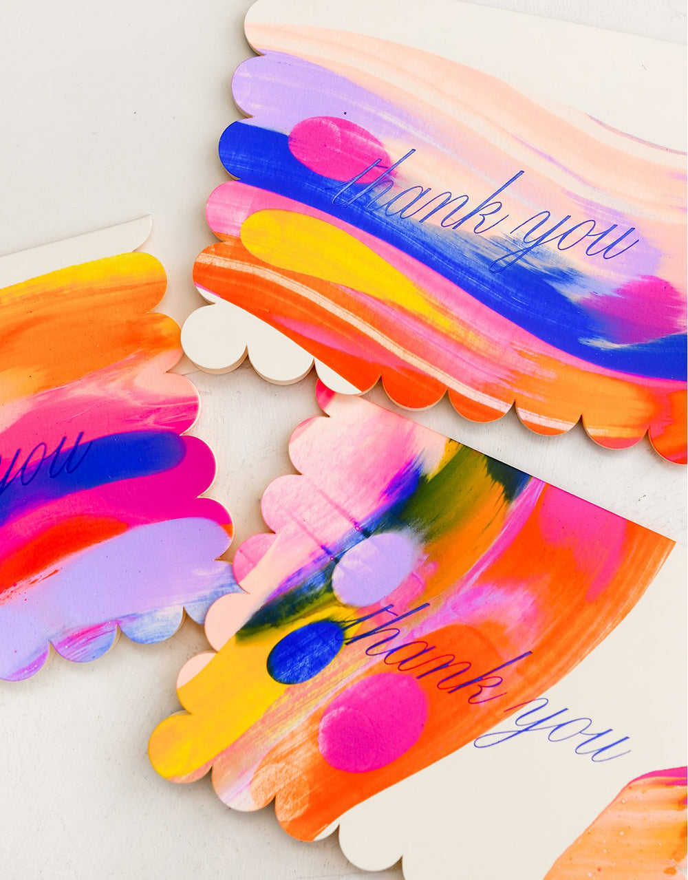 A neon marbleized thank you card set with scalloped edges.