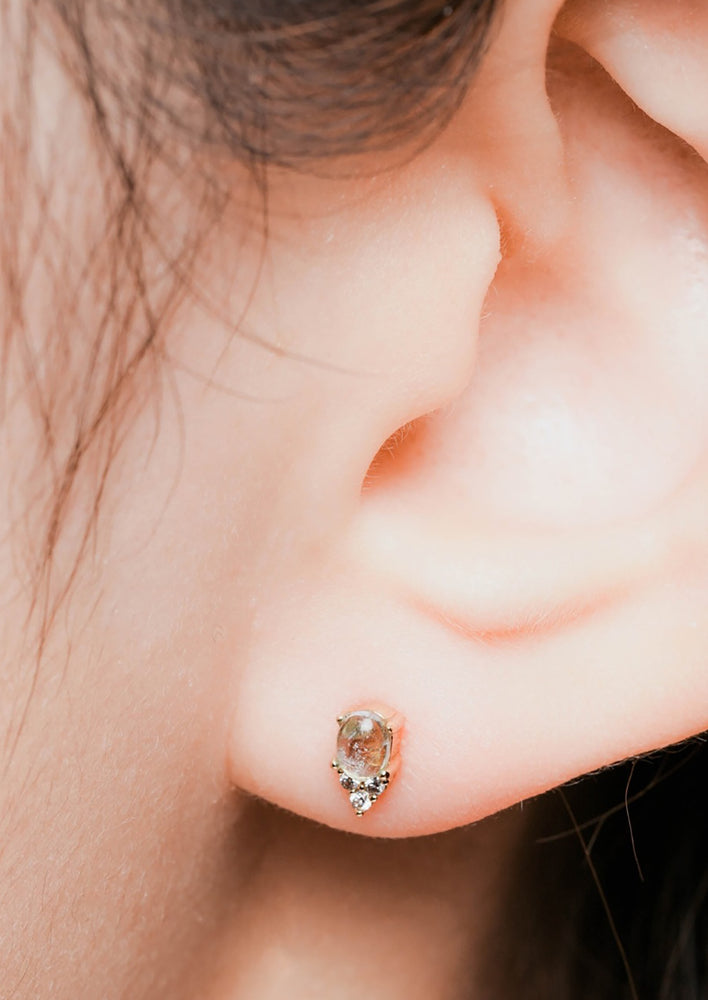 4: A pair of small aquamarine stud earrings in gold with crystal detail.