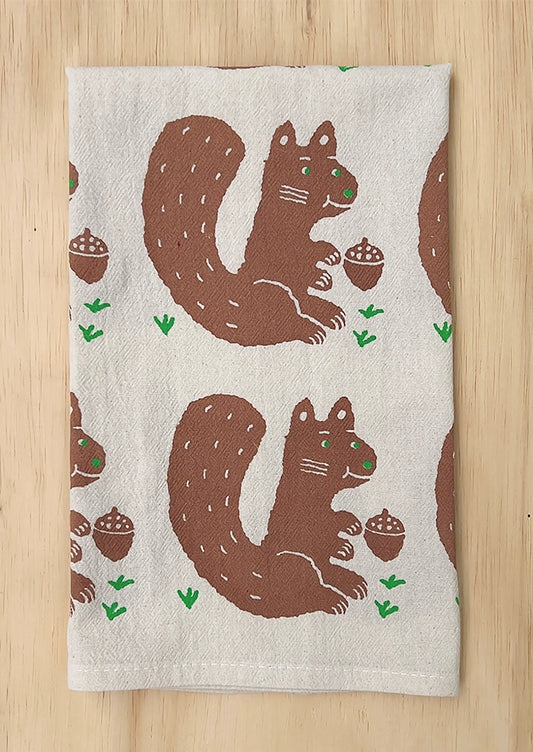 A folded tea towel with repeating squirrel motif.