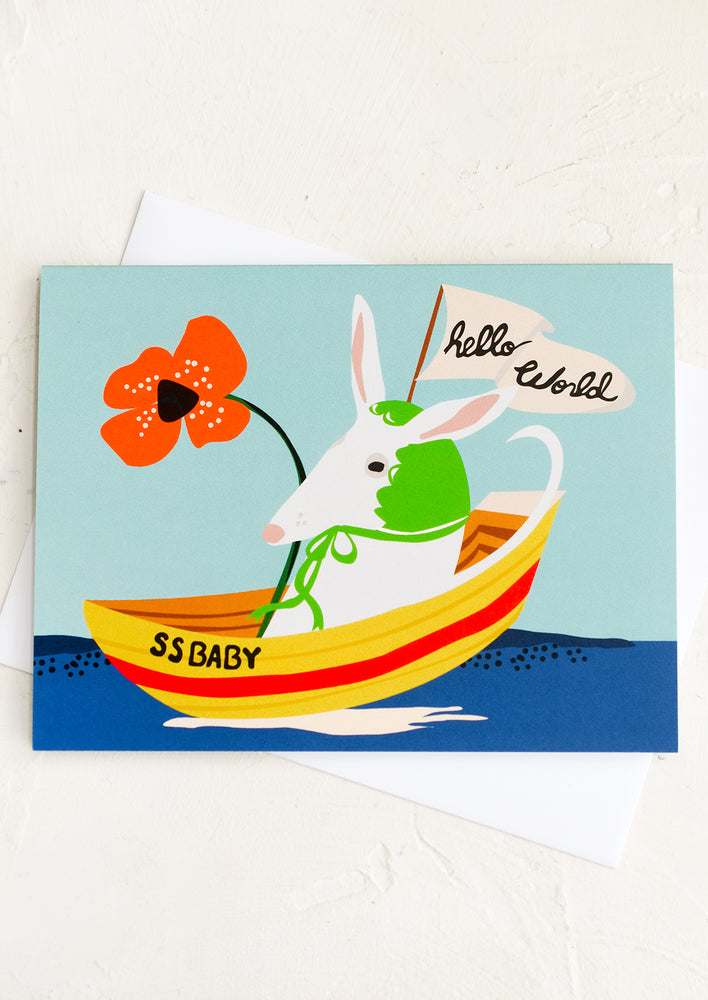 A card with bizarre image of giant goat wearing a bonnet in a boat, text reads "SS Baby - Hello World".