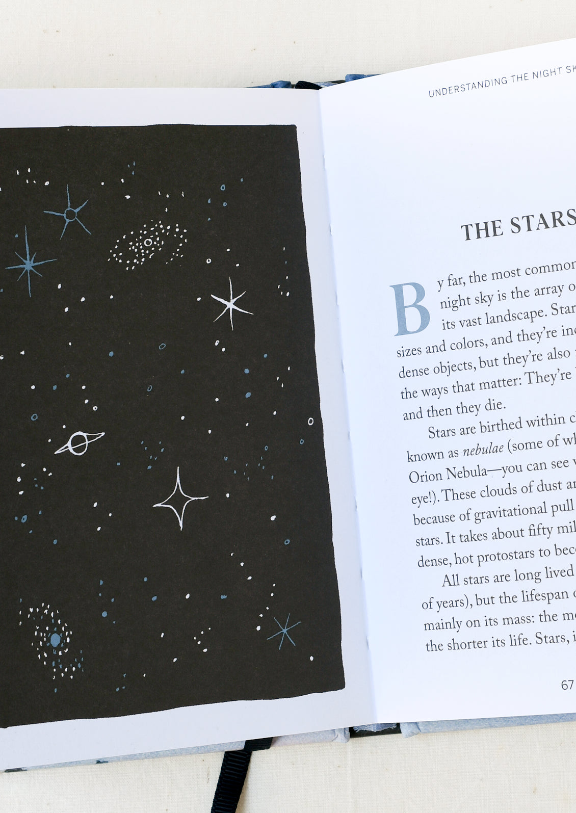 An open book with text about stars and an illustration of the galaxy.
