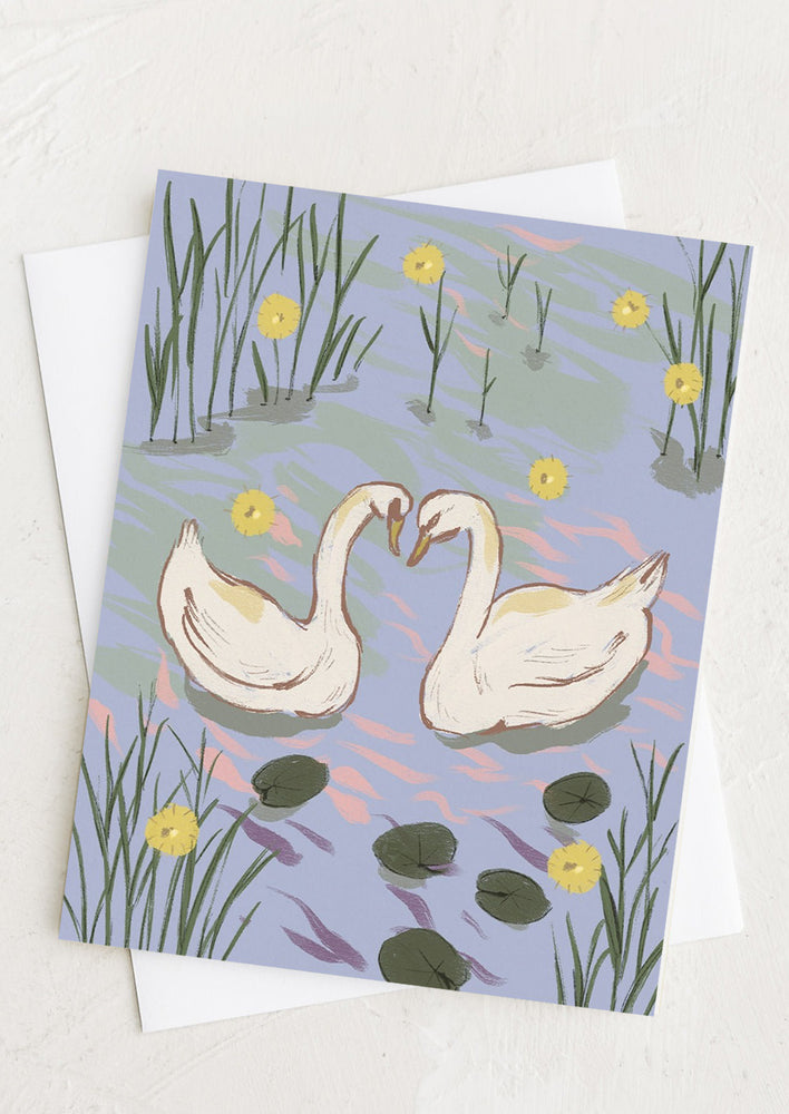 A greeting card with illustration of two swans in a river.