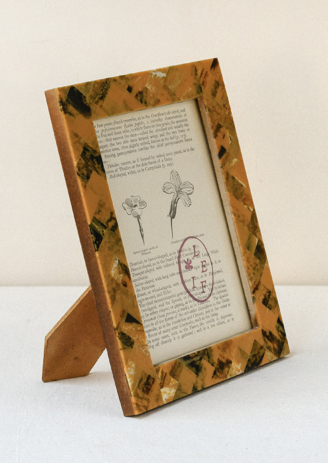 A 5" x 7" picture frame with a tiled design in a honey and marbled brown color.
