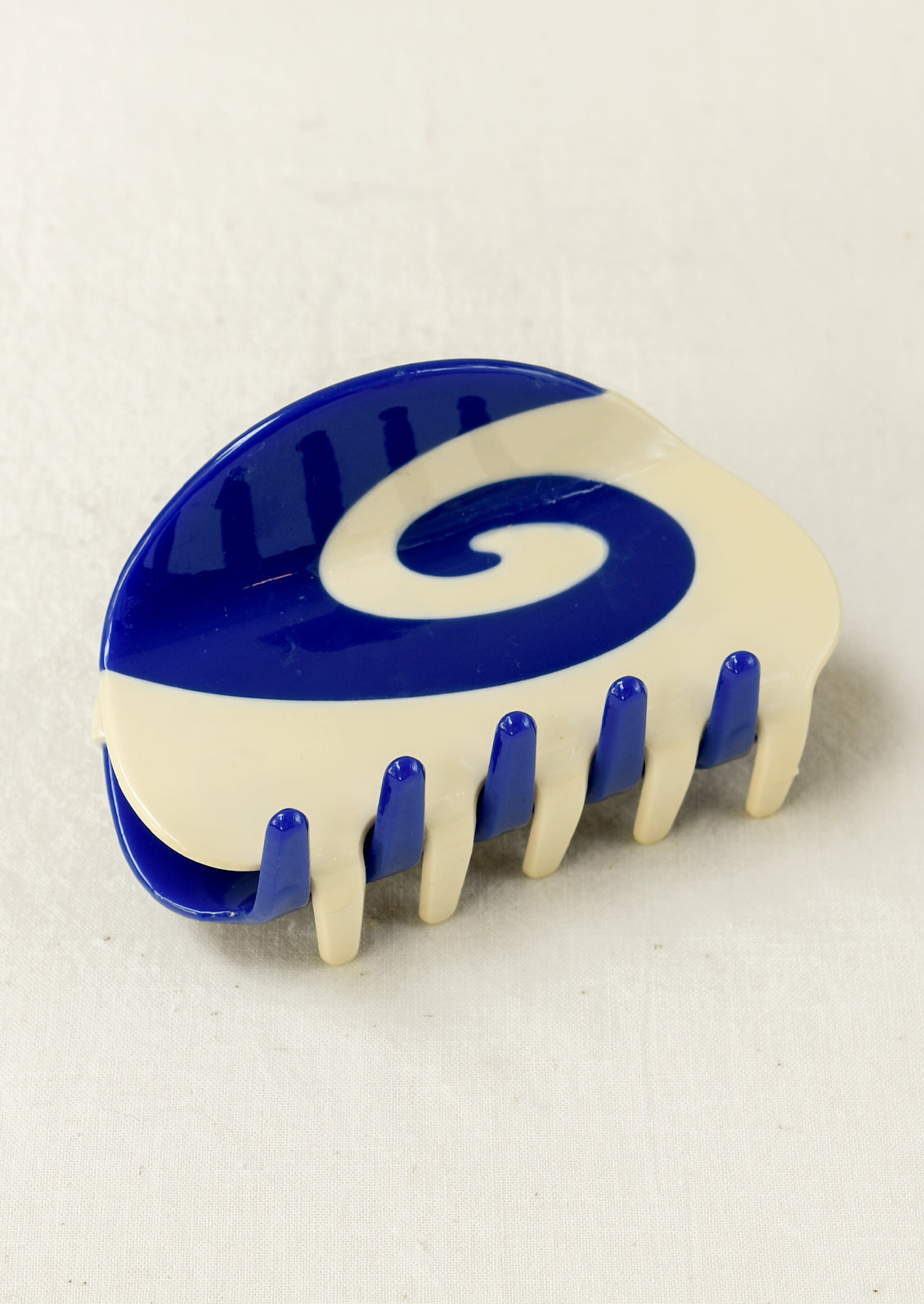 A hair claw clip with a blue and white spiral design.