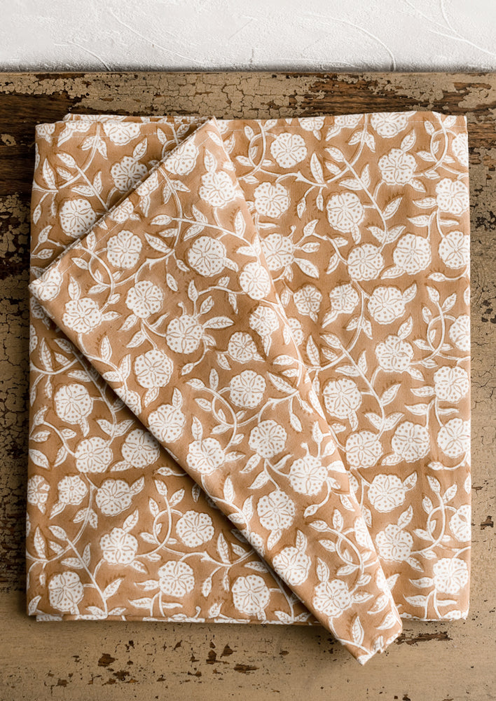 A block printed tablecloth in brown and white floral motif.
