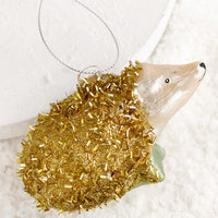 1: A holiday ornament of a hedgehog in gold tinsel.