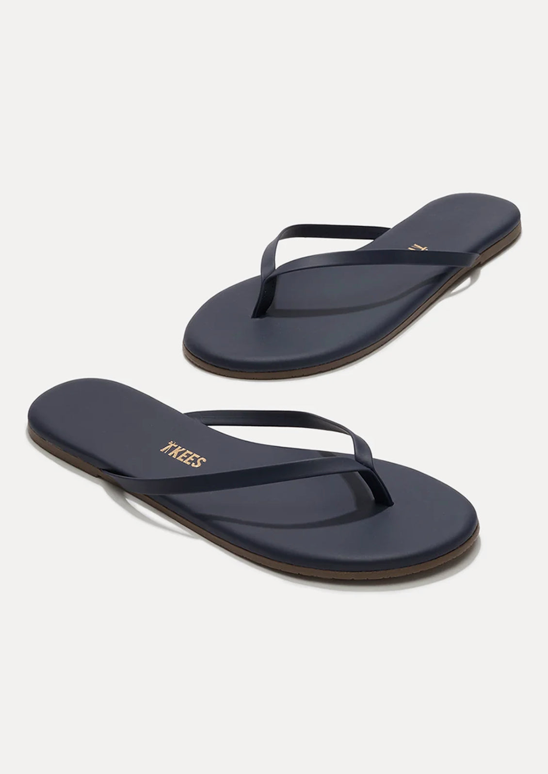 A pair of leather skinny strap TKEES sandals in dark navy.