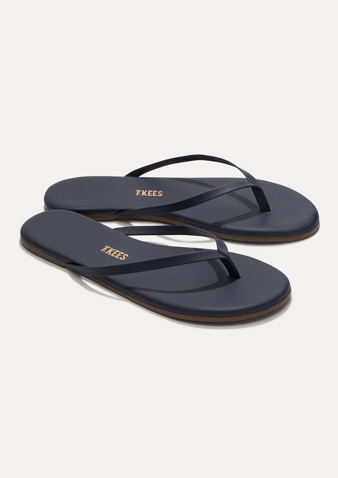 A pair of leather skinny strap TKEES sandals in dark navy.