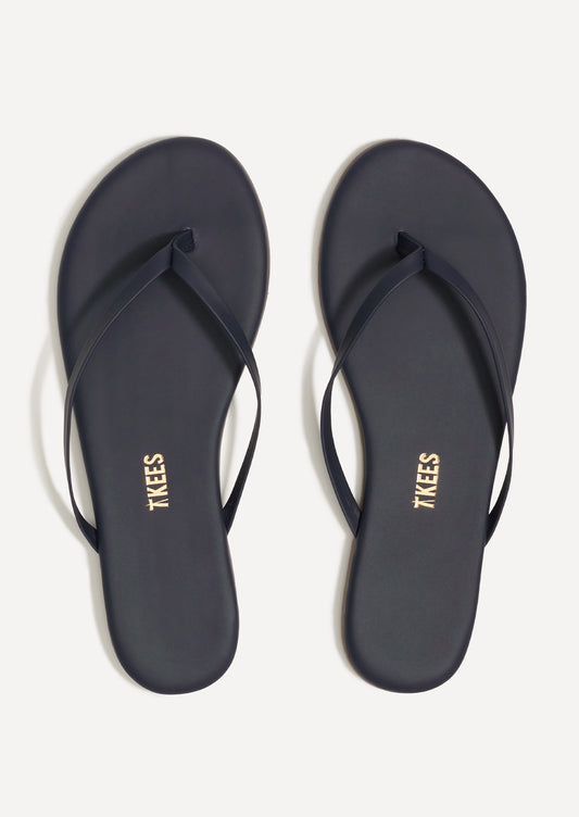 A pair of leather skinny strap TKEES sandals in dark navy.
