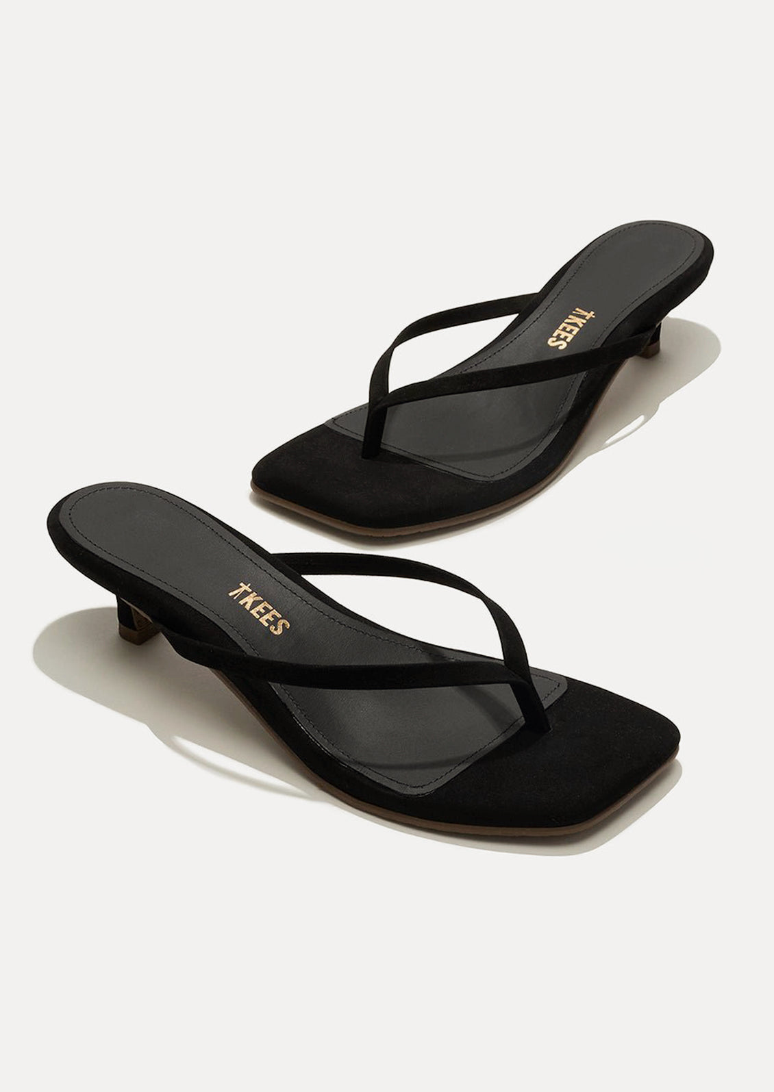 A pair of black suede kitten heel sandals with a square toe by TKEES.