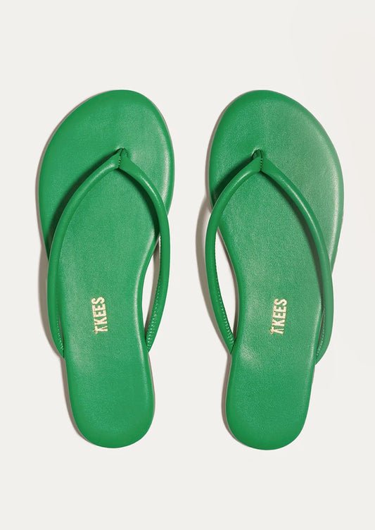 A pair of leather TKEES sandals with a tubular strap design in kelly green.