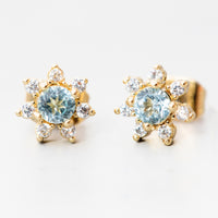 London Blue Topaz: A pair of flower shaped studs with gemstone and crystal in blue.