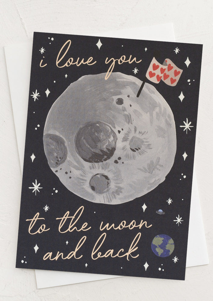 A card with moon print reading "I love you to the moon and back".