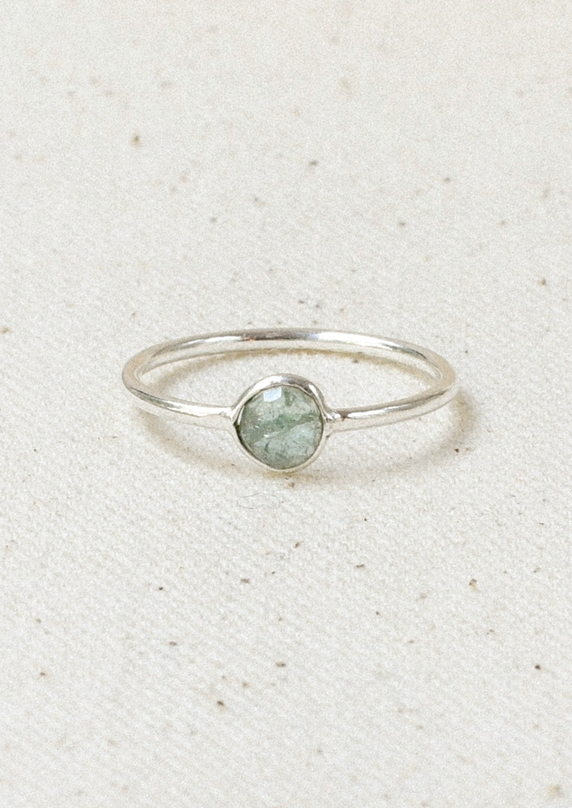 A sterling silver ring with a blue tourmaline  stone set in the center.