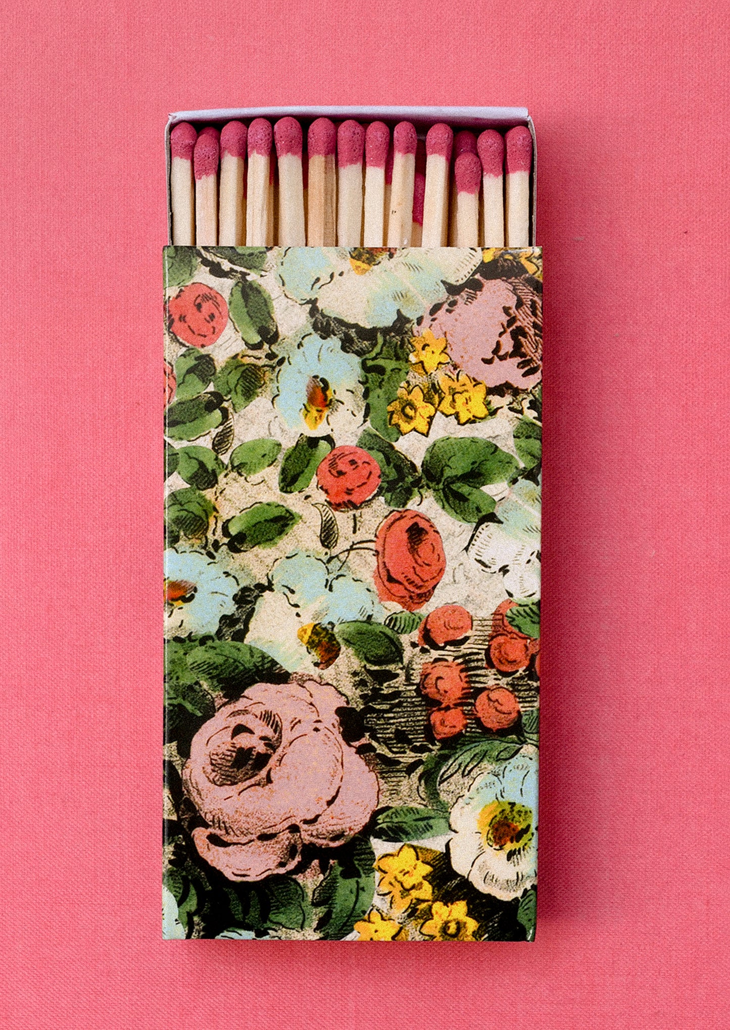 Matchbox with floral design on a pink background