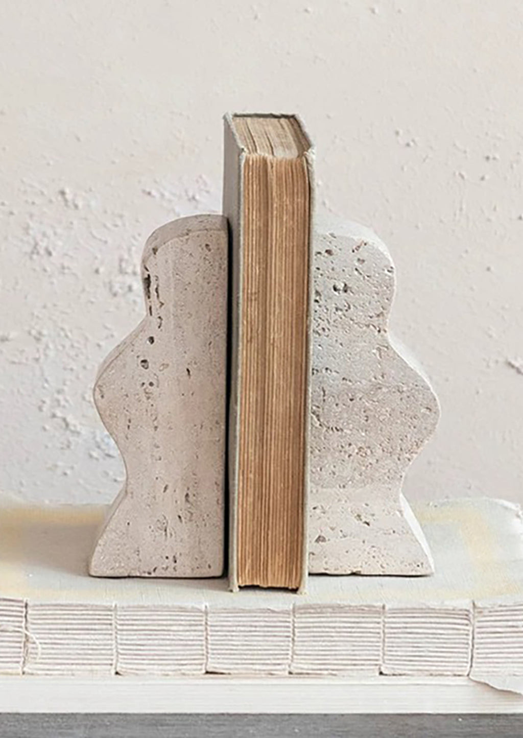1: A pair of natural travertine bookends with wavy squiggle shape.