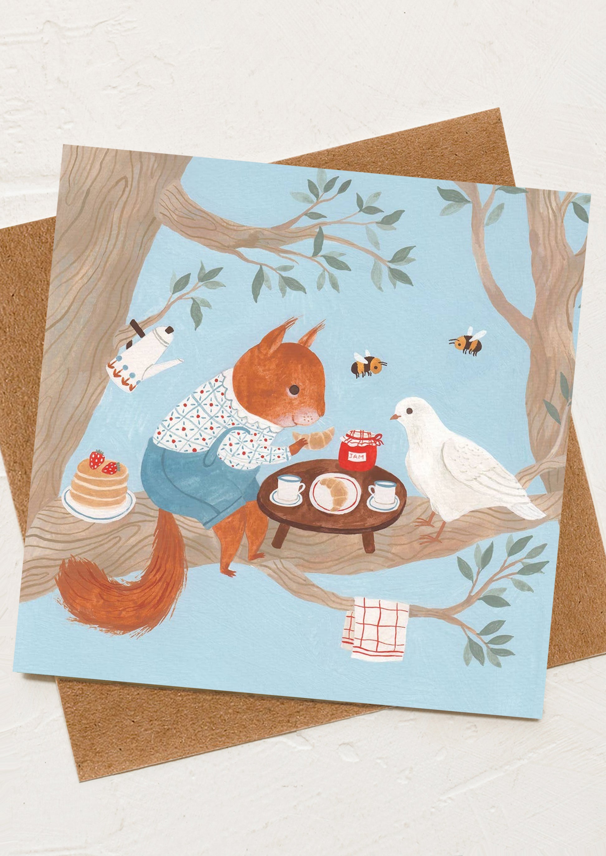 Card with illustration of a squirrel and dove in a forest setting, featuring a small table with tea set and cake.