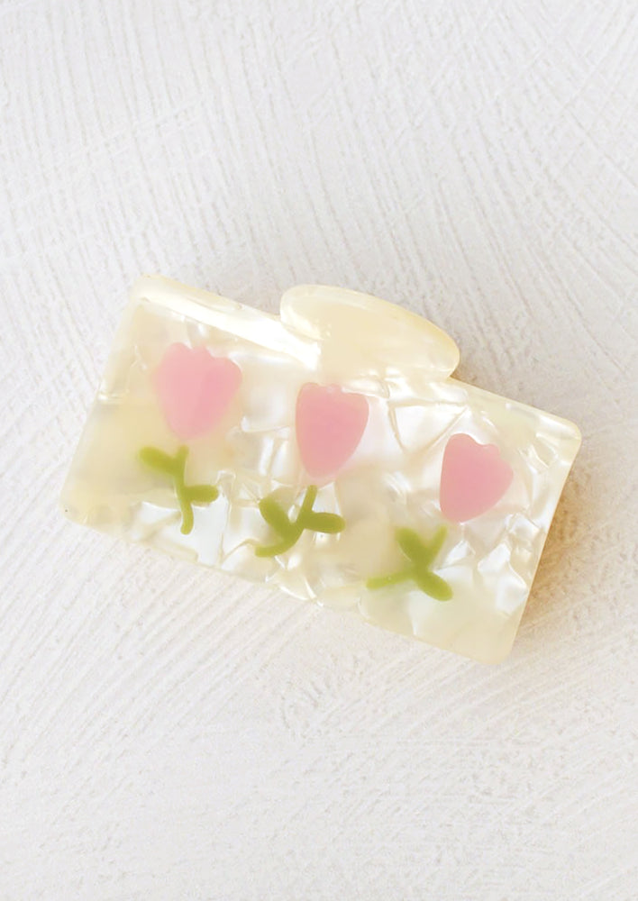 1: A rectangular hair claw with pearl finish with pink tulip design.