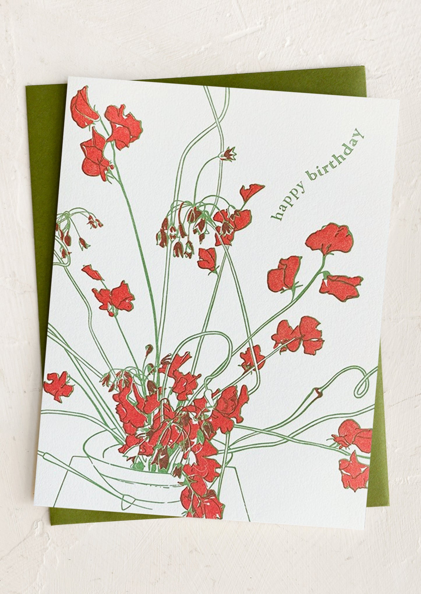 A red floral print card with text reading "Happy Birthday".