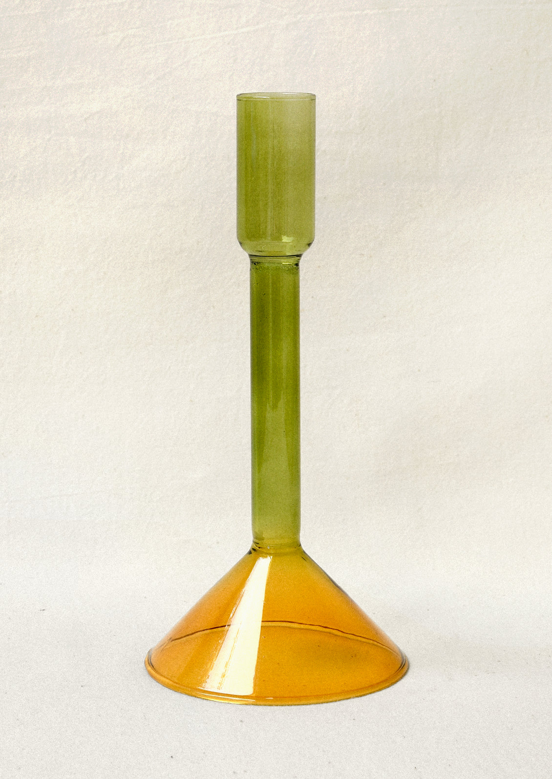 A two tone glass taper holder with a green stem and yellow base.