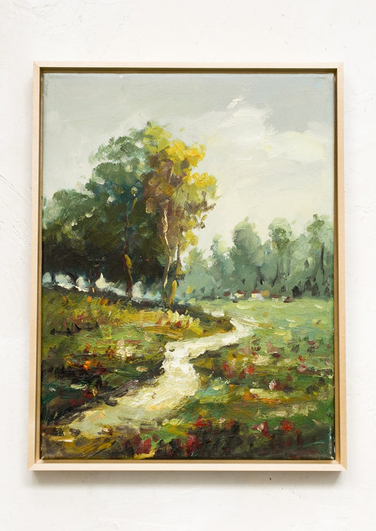 A framed landscape oil painting of a path running through a flowery meadow.